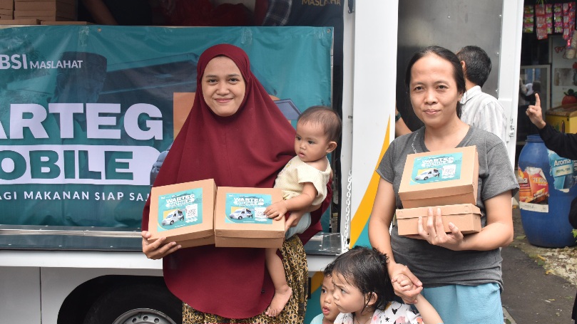 Dua orang ibu yang menerima paket makan siang dalam Program Warteg Mobile BSI Maslahat di kawasan Masjid Miftahul Jannah, Rempoa, Ciputat, Tangerang Selatan. (Foto: dok.BSI Maslahat for Warta Lentera)