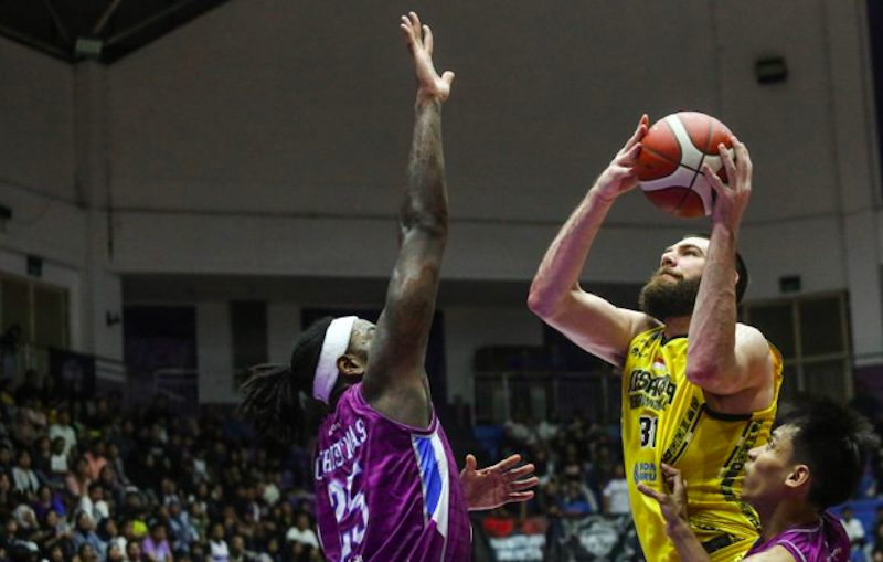 Kesatria Bengawan Solo William Joseph Artino (kanan) melakukan lay up dan diadang pebasket Hangtuah Jakarta Rakeem Maleek Christmas (kiri) pada pertandingan IBL 2025 di GOR Ciracas, Jakarta, Kamis (29/5/2025).(Dok. Antara)