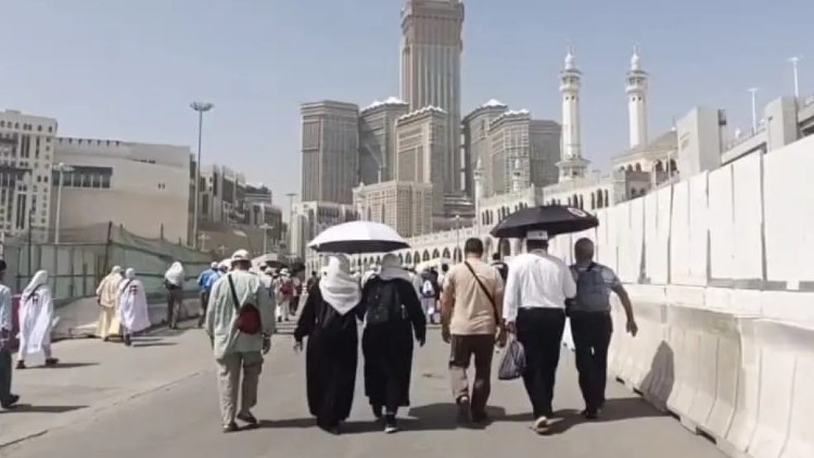 Sejumlah jamaah calon haji berjalan memayungi diri. Saat ini Arab Saudi memasuki musim panas ekstrem dengan suhu mencapai 45 derajat celcius. (Foto: dok. BP Haji).
