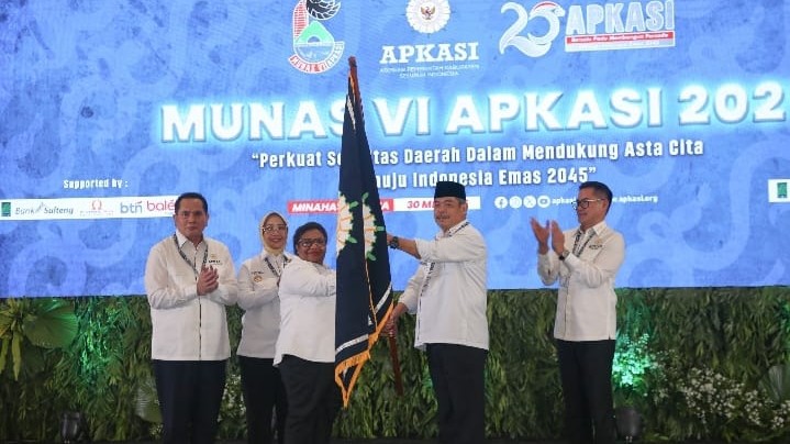 Wamendagri Ribka Haluk menyerahkan pataka kepada Ketua Umum Apkasi Masa Bhakti 2025-2030, Bursah Zarnubi, di ajang Munas VI Apkasi 2025. (Foto: dok. Apkasi)