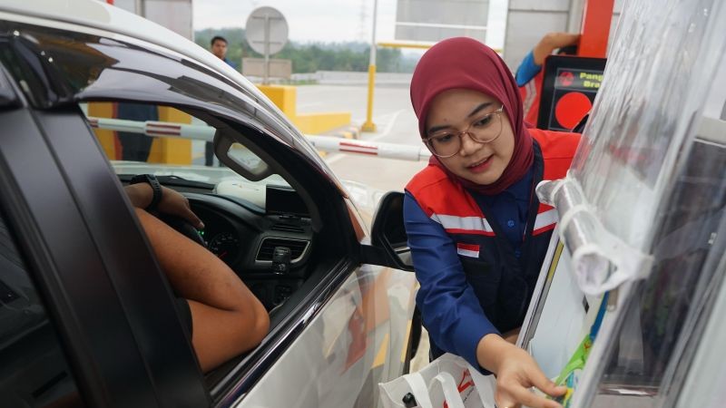 Petugas Tol Trans Sumatera membantu pengguna jalan saat memasuki gerbang tol. (Foto: dok. HKA)