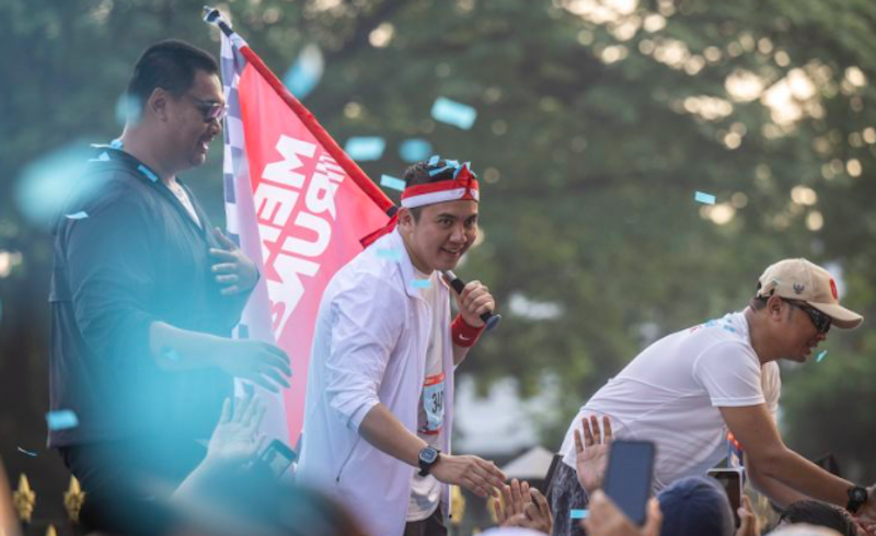 Menteri Sekretaris Negara Prasetyo Hadi (kanan) bersama Sekretaris Kabinet Teddy Indra Wijaya (tengah) dan Menpora Dito Ariotedjo (kiri) menyapa peserta Merdeka Run 8.0 K 2025. (Dok. Antara)