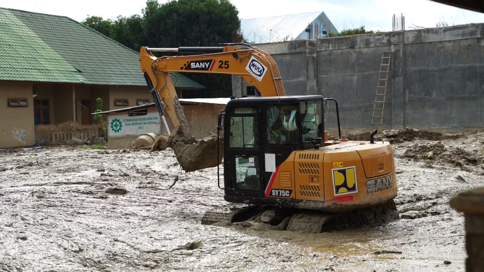 Alat berat terlihat masih membersihkan sisa-sisa lumpur yang terbawa banjir bandang di RSUD Tamiang, Aceh. (Dok Kementerian PU) 