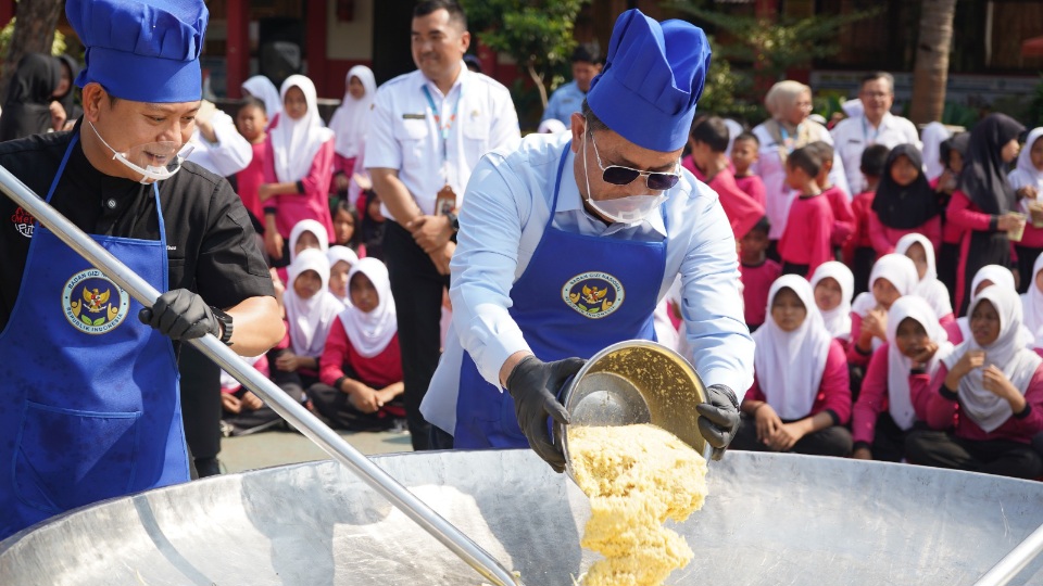 Influencer kuliner Bobon Santoso (kiri) turut memeriahkan kegiatan Masak Besar MBG di SDN 06 dan SDN 07 Pulo Gebang, Jakarta Timur, Rabu (15/4/2026). (Foto: Humas BGN for Warta Lentera)