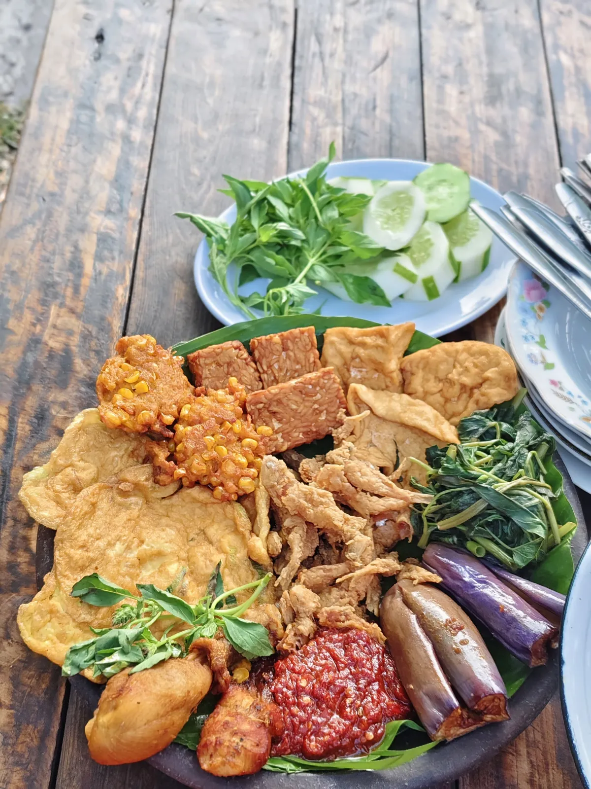 Aneka macam lauk, sambal, dan lalapan yang tersaji dalam satu cobek besar menggugah selera. (Foto : Emi Haris/Warta Lentera)